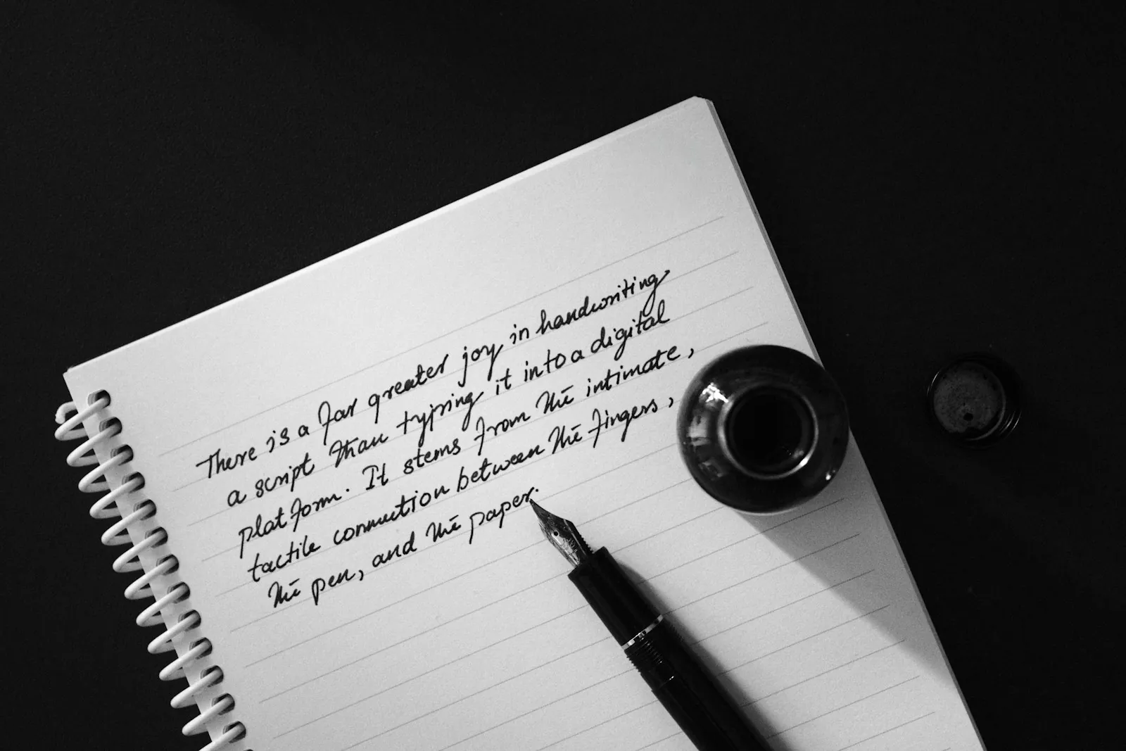 Fountain pen and inkwell on a notebook page with handwriting